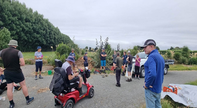 A group of people standing around a red electric scooter

Description automatically generated with low confidence