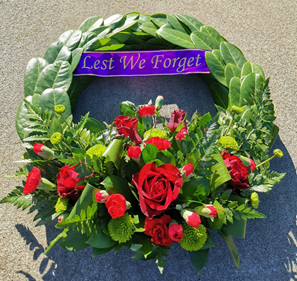 A wreath of flowers with a purple sign

Description automatically generated with low confidence