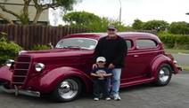 A person and child standing next to a car

Description automatically generated