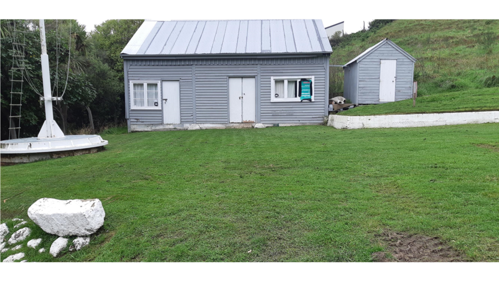 A house with a lawn and a hill behind it

Description automatically generated