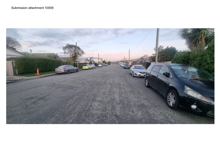 A road with cars parked on it

Description automatically generated