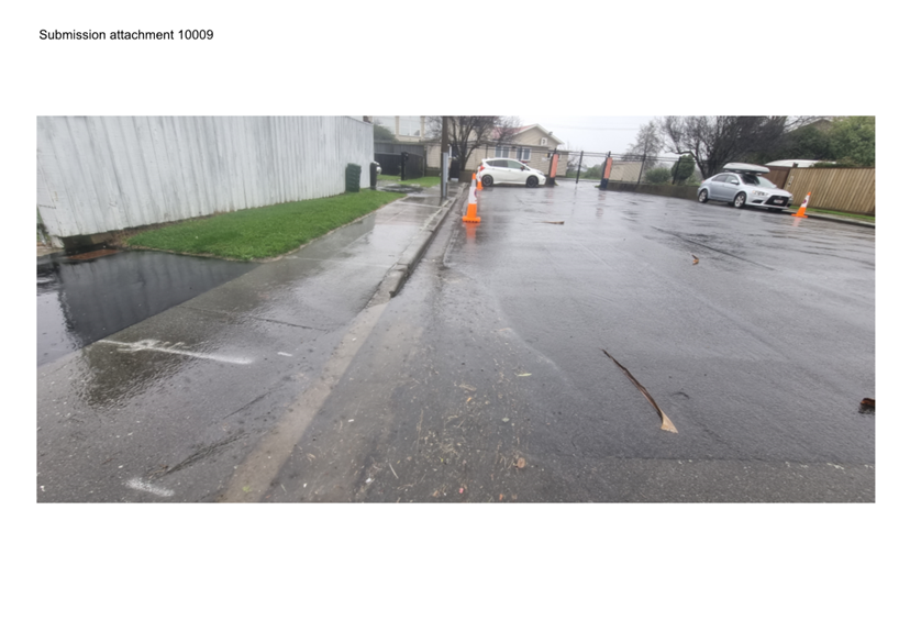 A road with a white fence and a white building

Description automatically generated