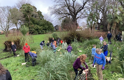 A group of people working in a garden

Description automatically generated