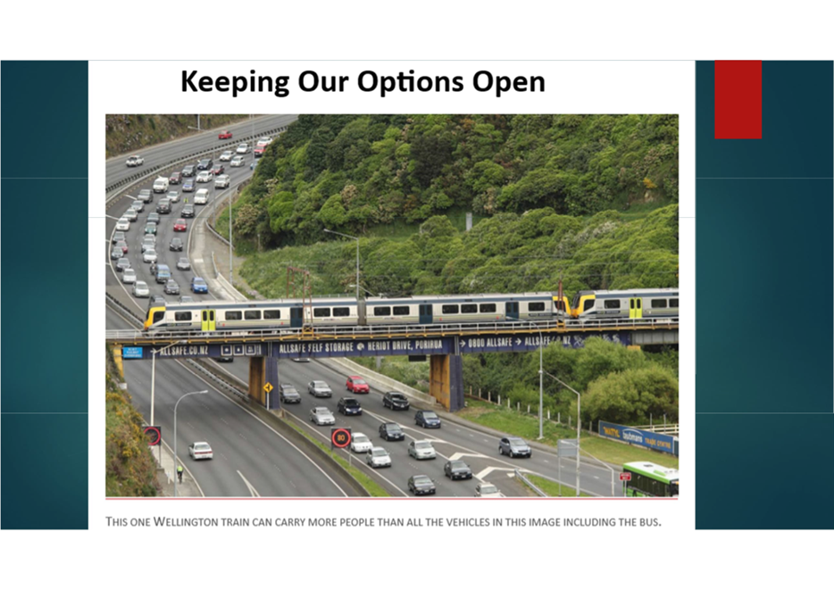 A train on a bridge over a highway

Description automatically generated