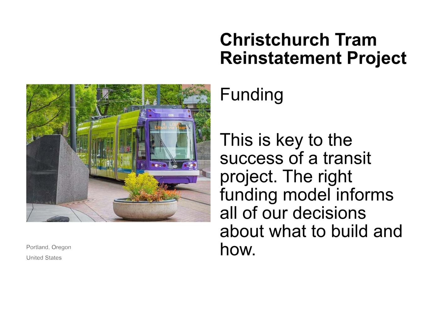 A purple and green tram on a sidewalk

Description automatically generated
