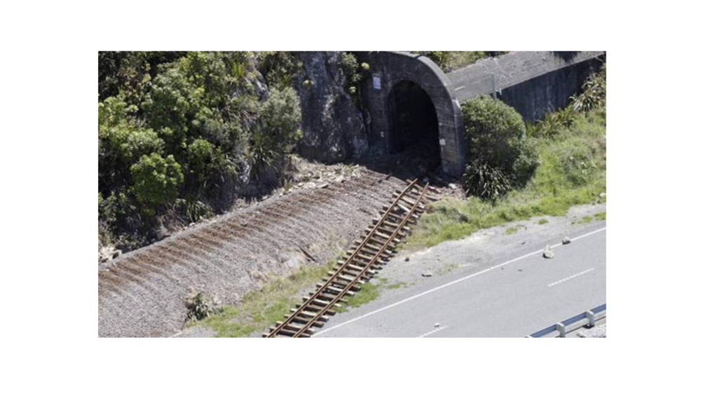 A train tracks next to a tunnel

Description automatically generated