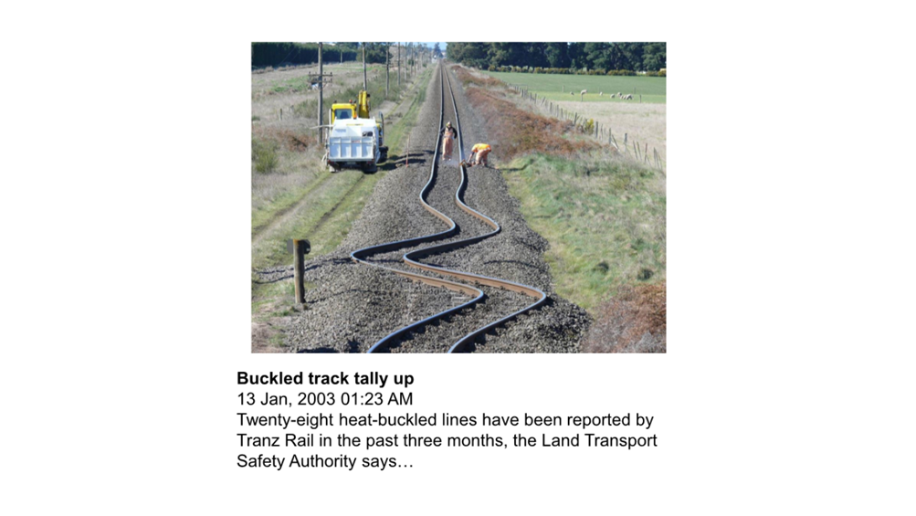 A train tracks with a truck in the background

Description automatically generated
