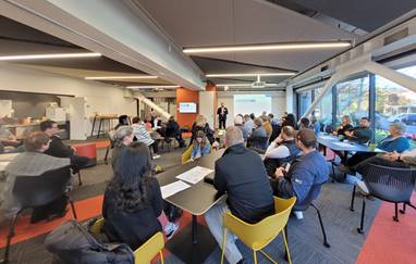 A group of people sitting at tables in a room

Description automatically generated