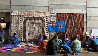 Fijian cultural group sitting in front of the display 