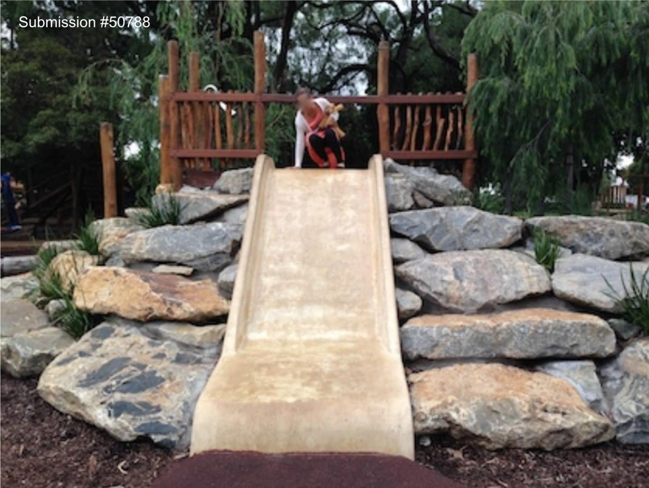 A child playing on a slide

Description automatically generated