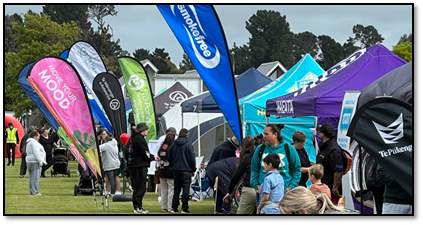 A group of people standing in a field with tents

Description automatically generated