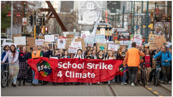 A group of people holding signs and placards

Description automatically generated