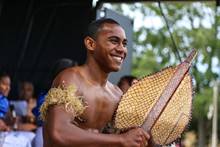 A man as part of a cultural group, performing on stage.