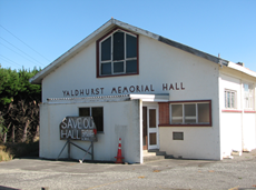 A white building with a sign on the front

Description automatically generated