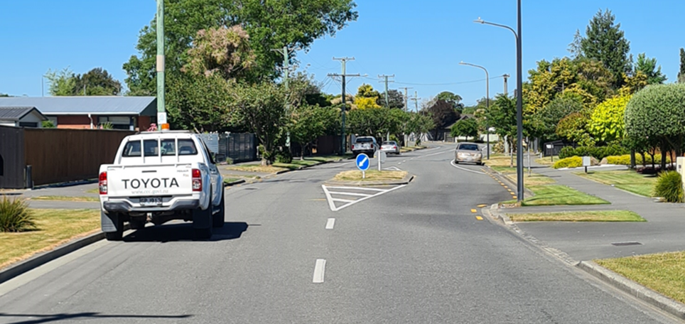 A road with cars and trees

Description automatically generated