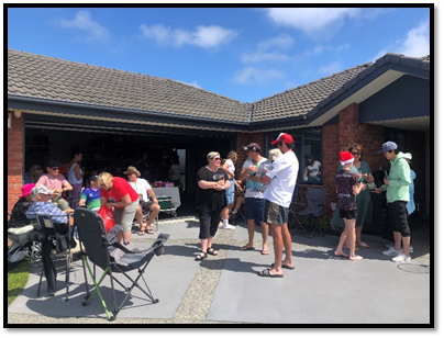A group of neighbours talking outside a house. 