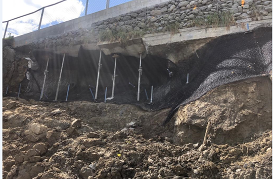 A road with rocks and metal poles

Description automatically generated with medium confidence