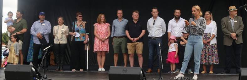 A group of people standing on a stage

Description automatically generated