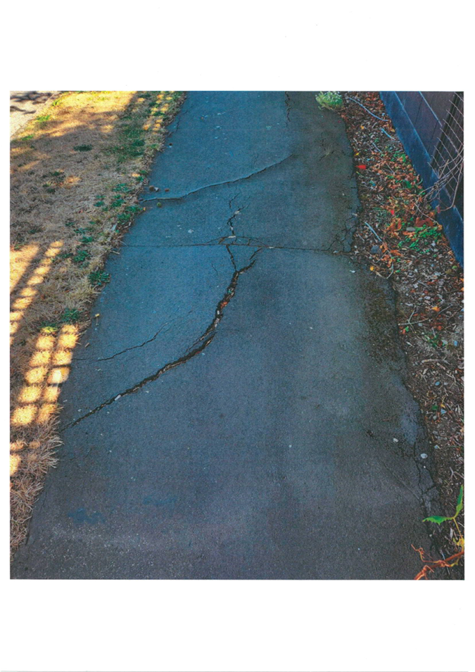 A cracked road with a crack in the middle

Description automatically generated with medium confidence