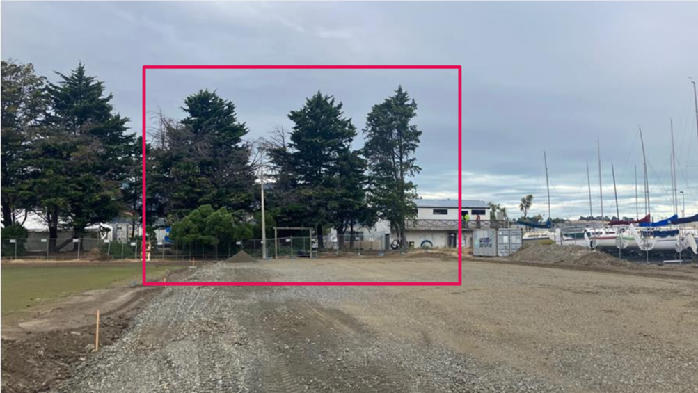 A dirt road with trees in the background

Description automatically generated