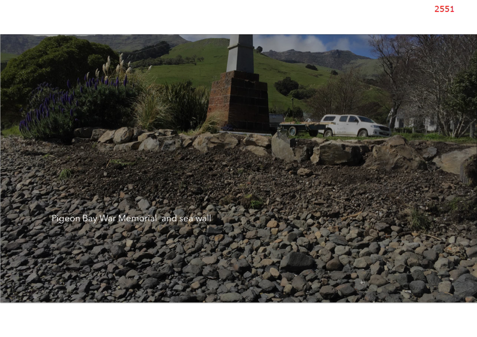 A rocky area with a monument and a car parked on it

Description automatically generated