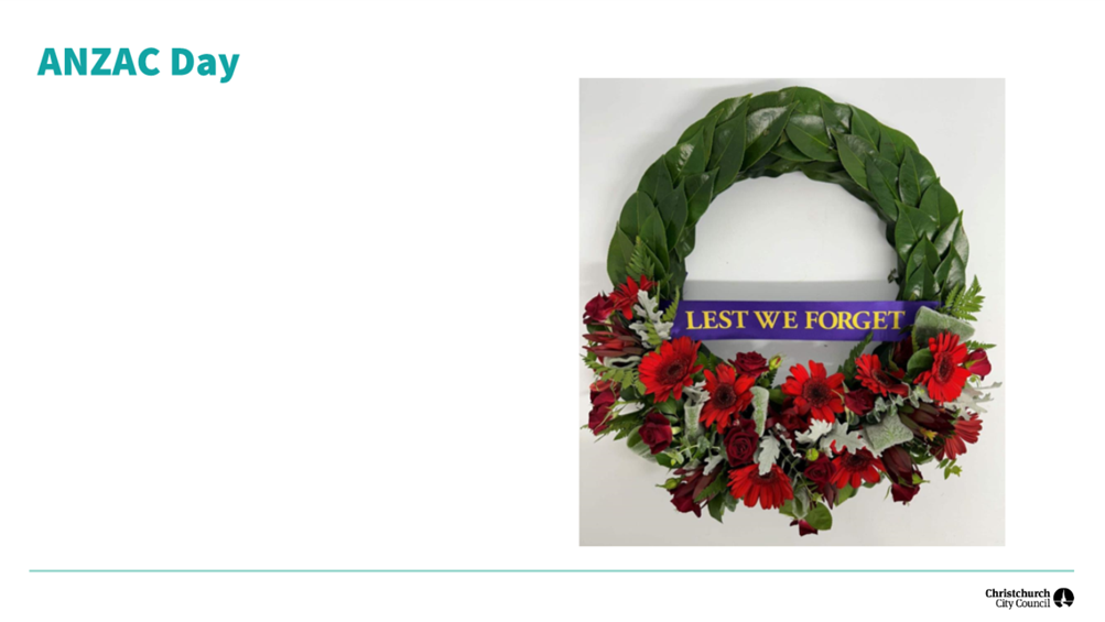 A wreath with flowers and a blue sign

Description automatically generated