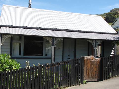 A house with a fence and a gate

Description automatically generated