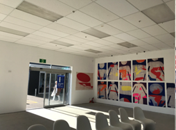 A room with white chairs and a glass door

Description automatically generated