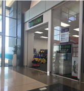 A building with glass doors and a toy car

Description automatically generated