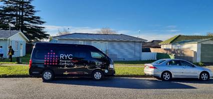 A black Riccarton Youth Community van parked on the side of a road in front of the Hornby Youth Hangout.
