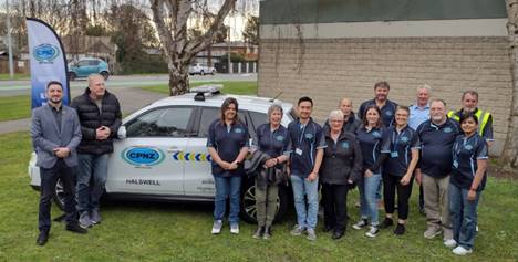 A group of Halswell Community Patrol members, standing outside in front of the new patrol car
