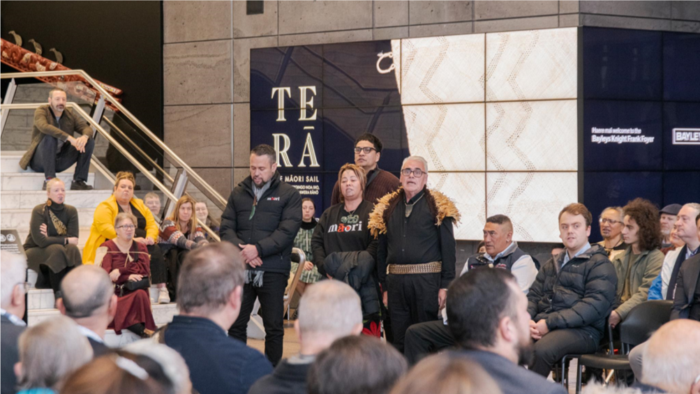 A group of people standing in front of a crowd

Description automatically generated