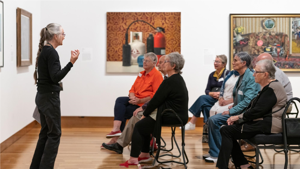 A person standing in front of a group of people

Description automatically generated