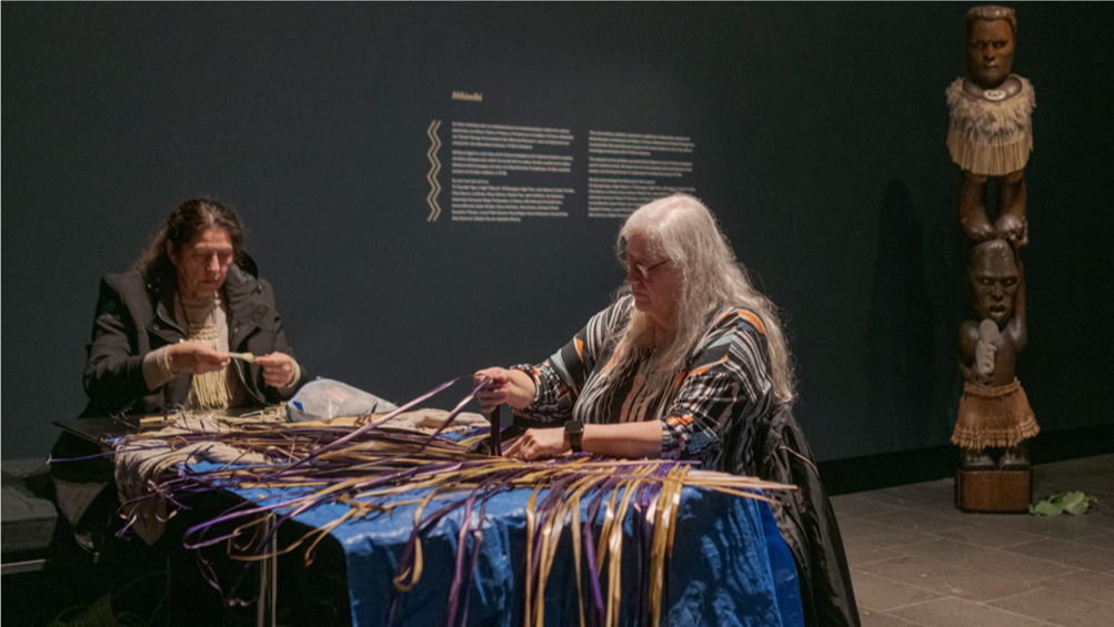 A person sitting at a table with a blue tablecloth and a person sitting at a table

Description automatically generated
