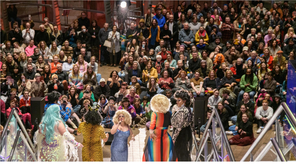 A group of people performing in front of a crowd

Description automatically generated