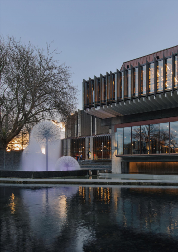 A building with a fountain and a pond

Description automatically generated
