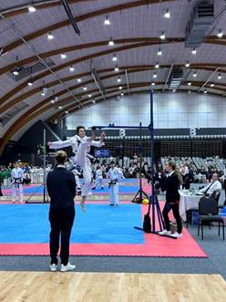 Misha Worboys doing a high kick during the Taekwon Do National Championships in a sports hall.