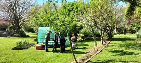 A photo of three or four people standing together at the Halswell Community Garden area amongst a number of trees.
