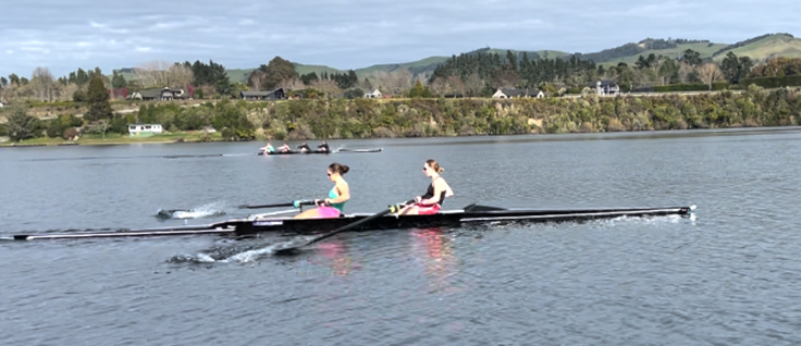 A group of people rowing on a lake

Description automatically generated