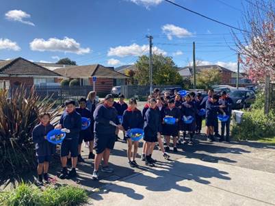 A group of people standing on a street

Description automatically generated