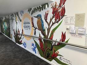 A wall with a mural of a bird and flowers

Description automatically generated