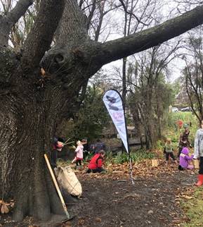A group of people, mostly children maintaining a park area.