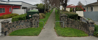 A sidewalk with grass and trees

Description automatically generated