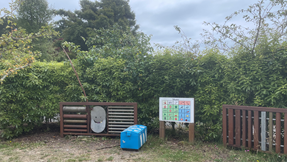 A sign and a box in a yard

Description automatically generated with medium confidence