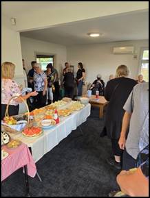A group of people standing around a table full of food

AI-generated content may be incorrect.