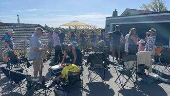 A group of people outside with chairs

AI-generated content may be incorrect.