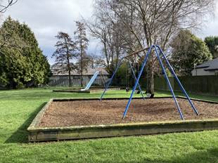 A playground with a slide and a slide in the middle

Description automatically generated