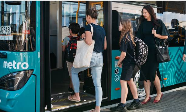 A group of people boarding a bus.
