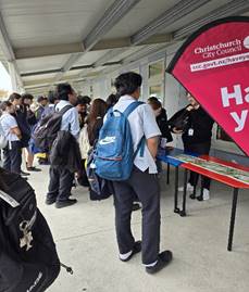 A group of students standing around a table.
