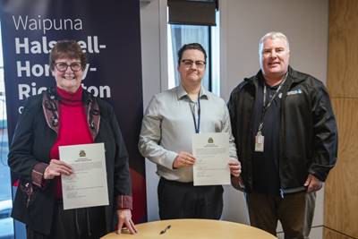 Board members Helen Broughton, Luke Chandler standing and holding Luke's declaration and Governance Team Manager Matthew McLintock standing together

